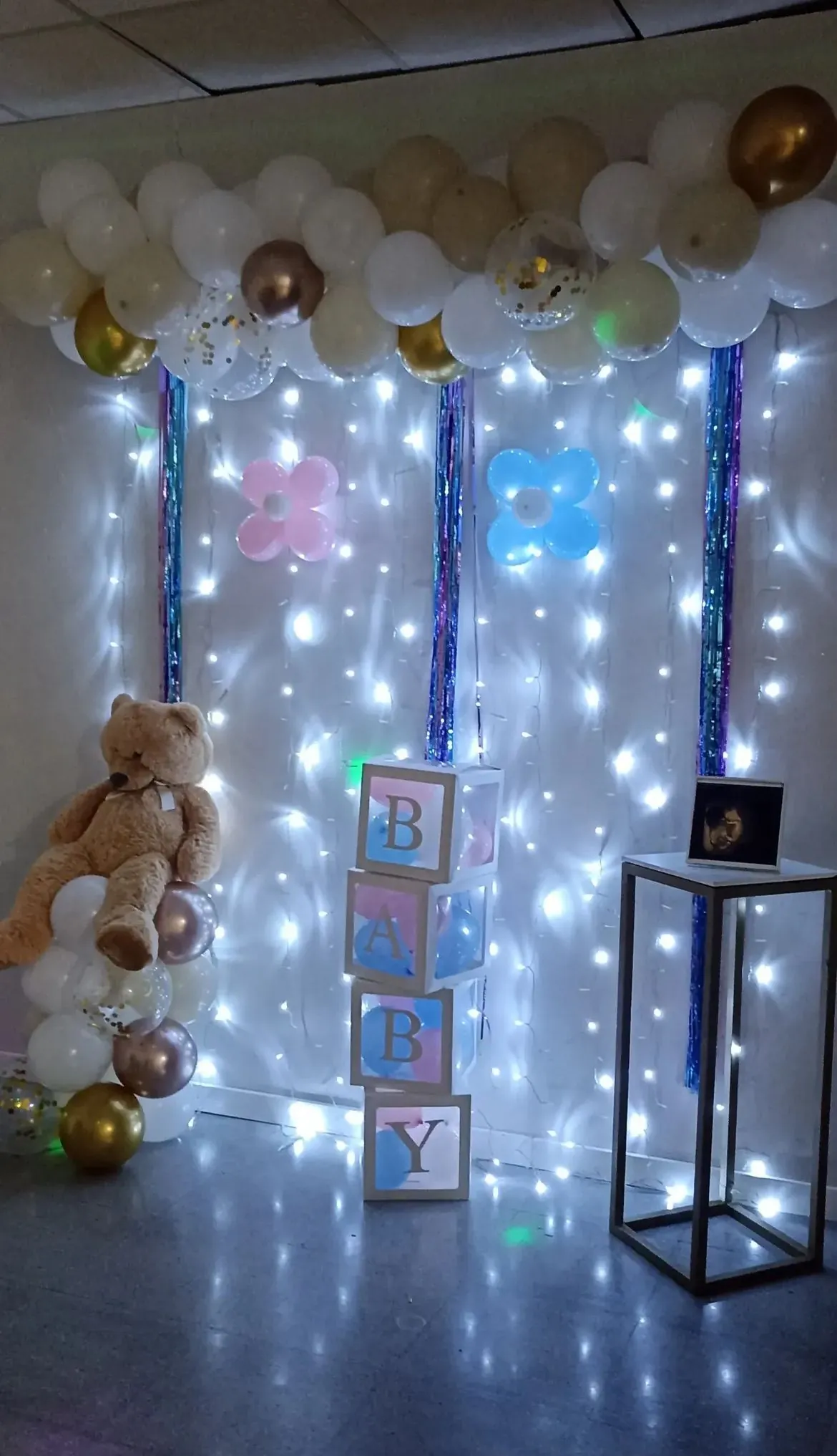 Sala para baby shower en Sabadell con cortina de luces, globos pastel y oso gigante